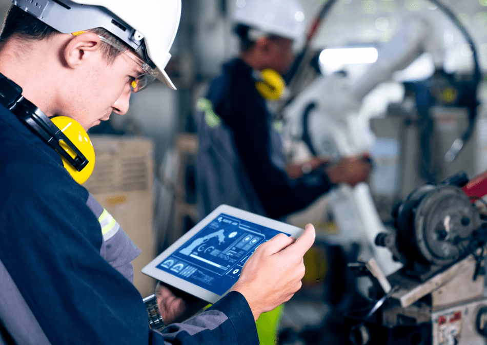 A worker is using a tablet in a factory.