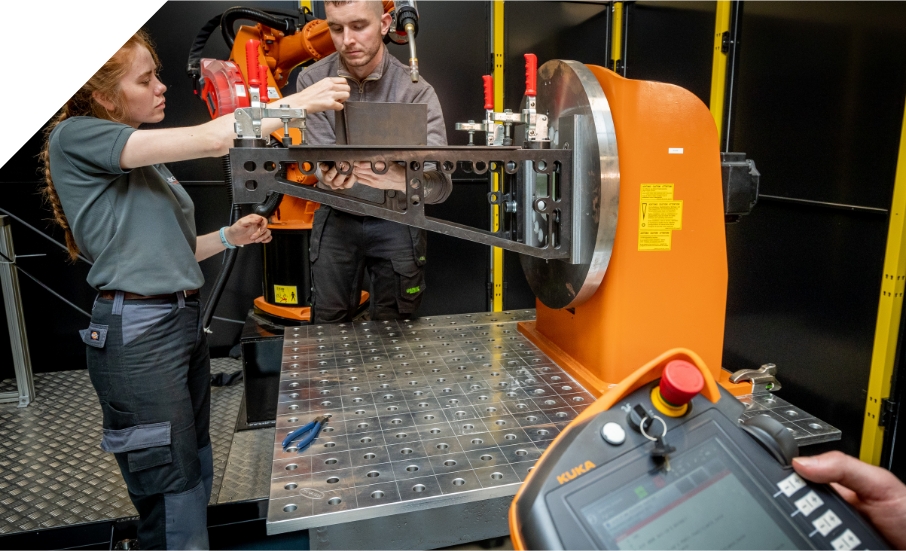 Two people working on a machine in a factory.