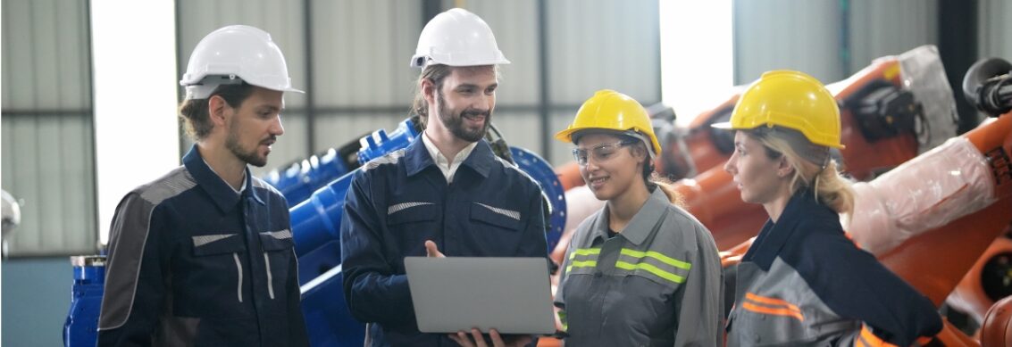 A group of people in hard hats standing in a factory.