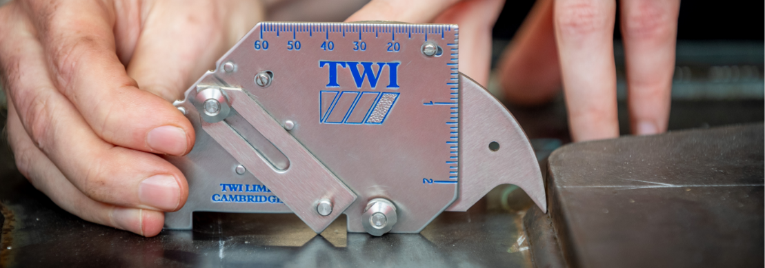 A person using a metal ruler to measure a piece of metal.